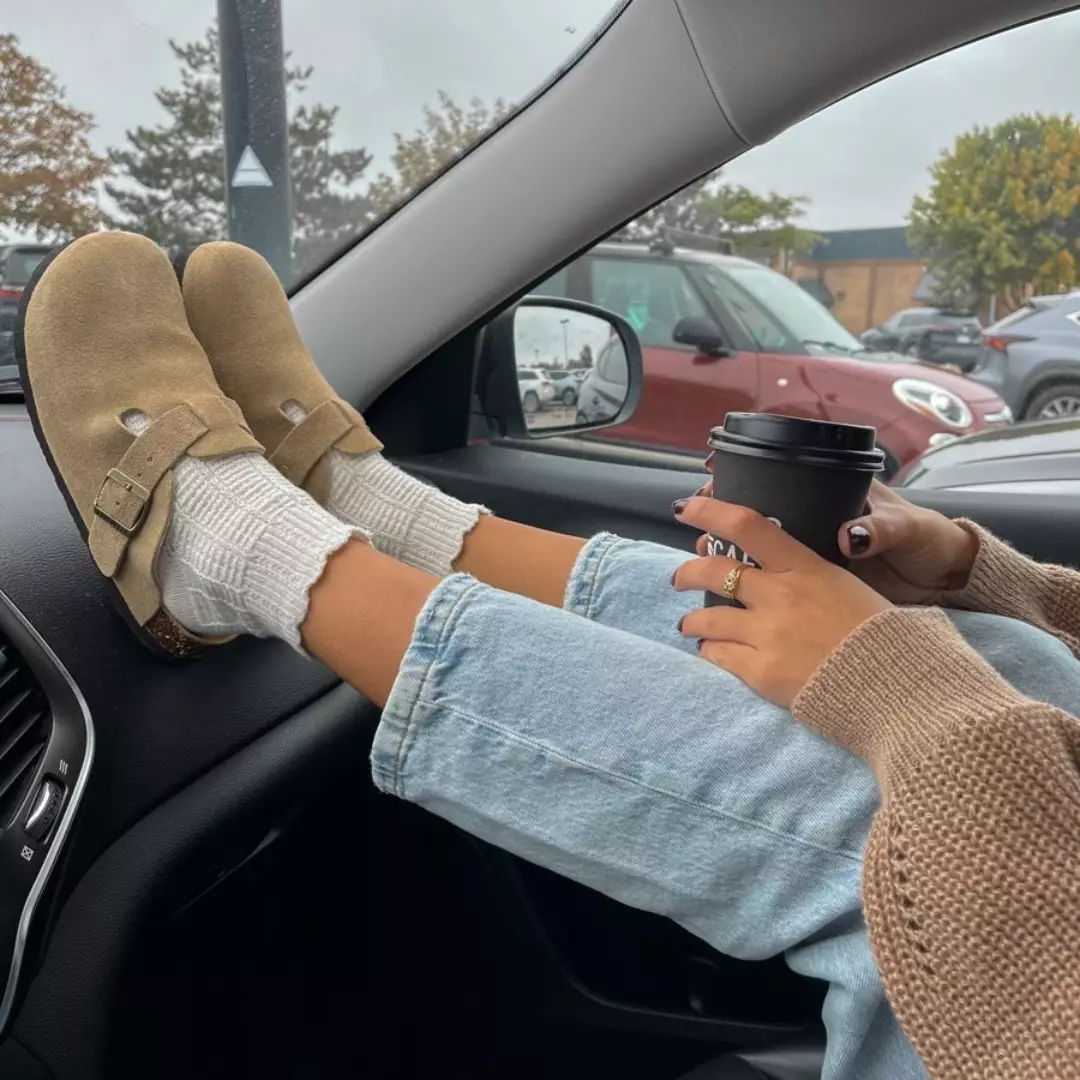 Taupe clogs on a car dashboard